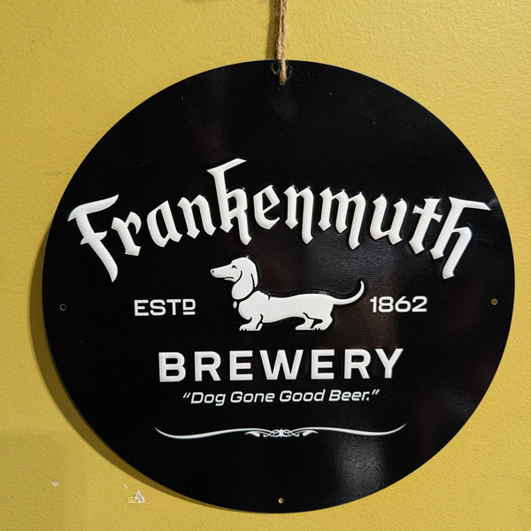 Round black sign with white text and dachshund graphic on a yellow wall